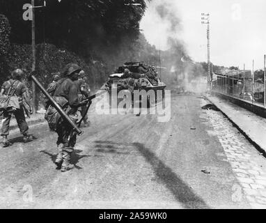 8/23/1944 - Avec la fumée des blindés allemands dynamité remplissant le ciel, ces troupes américaines Passer à Fontainebleau en route vers Paris, France Banque D'Images