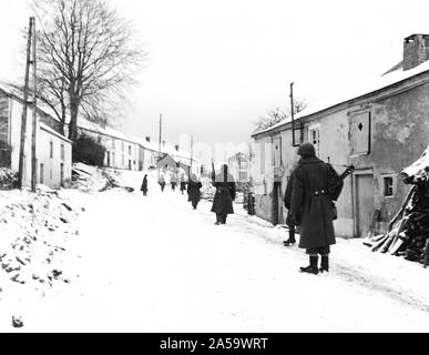 À la recherche de tireurs d'allemand, une escouade de fantassins Troisième armée avancer avec prudence dans les rues de Moircy, Belgique. 31/12/44 Banque D'Images