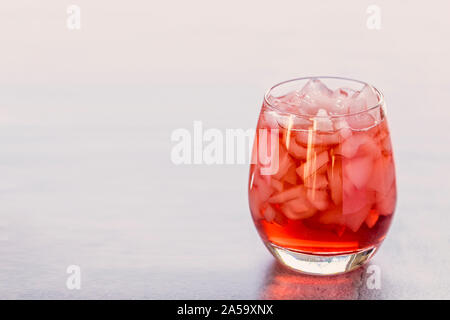 Close-up d'une rafraîchissante boisson translucide rouge avec de la glace. Le verre peut être jus de framboises fraises ou le squash. Il y a copie espace à gauche et th Banque D'Images