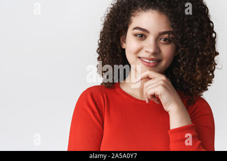 Close-up smart curieux bonne-femme intelligente à la dark curly hairstyle touch chin smiling satisfait audience idée intéressante réflexion décision rechercher Banque D'Images