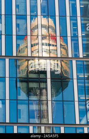 Le haut de la Tour de Sydney, Sydney plus haute structure, anciennement connu sous le nom de Centrepoint Tower, reflétée dans le mur rideau en verre d'un autre bâtiment Banque D'Images