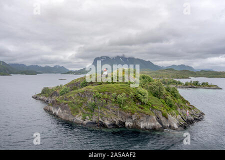 Cercle arctique paysage fjord avec petite balise sur un vert falaise de falaises vert archipel, tourné en cas de forte lumière près de nuageux, Austvagoy Brottoya Banque D'Images