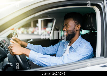 Happy young african american man driving a car Banque D'Images