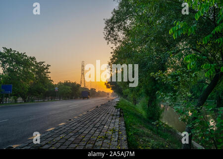 Belle route droite au lever du soleil, Canal de Lahore au Pakistan Banque D'Images