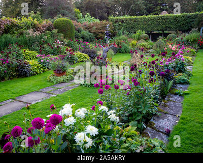 Le jardin en contrebas à Chenies Manor dans le Buckinghamshire sur une soirée de fin d'été avec des variétés dahia, centré autour de l'étang ornemental. Banque D'Images