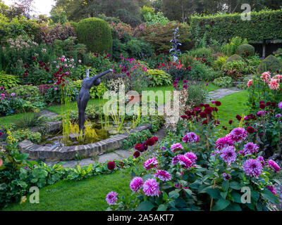 Le jardin en contrebas à Chenies Manor dans le Buckinghamshire sur une soirée de fin d'été avec des variétés dahia, centré autour de l'étang ornemental. Banque D'Images