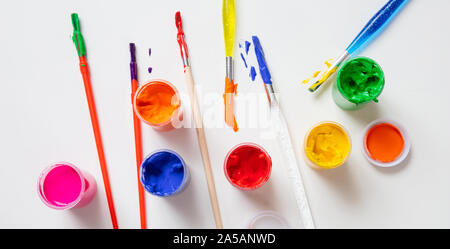 La créativité des enfants. Les peintures au doigt et coloré Jeu de pinceaux sur fond de couleur blanche, vue du dessus Banque D'Images