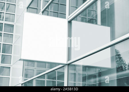 Outdoor entreprises pancarte accroché sur la paroi de verre du centre d'affaires, avec copie espace maquette de signalisation dans les tons bleus, affiche murale photo Banque D'Images