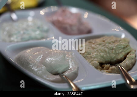 Partie de l'immense meze repas servi souvent à Chypre. Sur cette photo vous pouvez voir différentes sauces sur petites plaques sur une table avec nappe verte. Banque D'Images