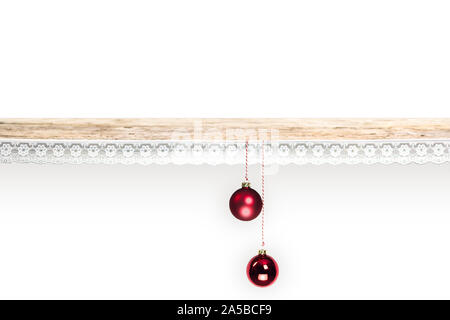 Une vieille planche en bois décoré avec de la dentelle. 2 boules de Noël rouge sont accrochés à l'avant. Fond blanc laisse beaucoup d'espace pour copier votre propre conception. Banque D'Images