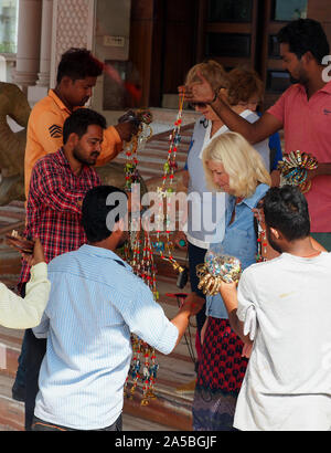 Les touristes avec les vendeurs de souvenirs près du Taj Mahal à Agra, Inde. Banque D'Images