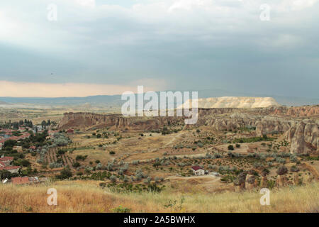 Paysage paisible de la Cappadoce, Turquie. Des maisons blanches aux toits rouges entouré par les arbres et collines. Banque D'Images