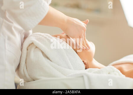 Esthéticienne Massage du visage permet à la fille Banque D'Images