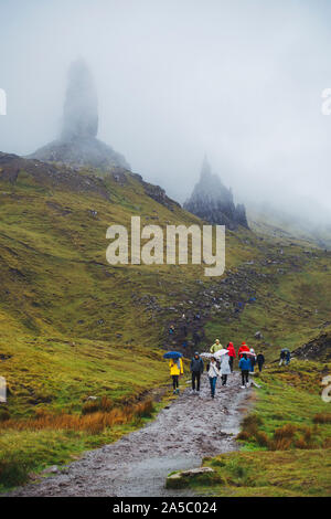 Don d'imperméables et de parapluies les touristes sur un jour nuageux, des pluies à l'ancien homme de Storr, un célèbre rock formation sur l'île de Skye, Écosse Banque D'Images