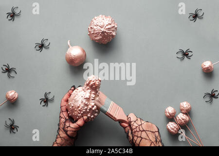 Halloween créatif mise à plat sur fond de papier gris avec des citrouilles et des araignées, copiez-espace. Mains en noir et métal décoratif coloriage citrouilles moi Banque D'Images