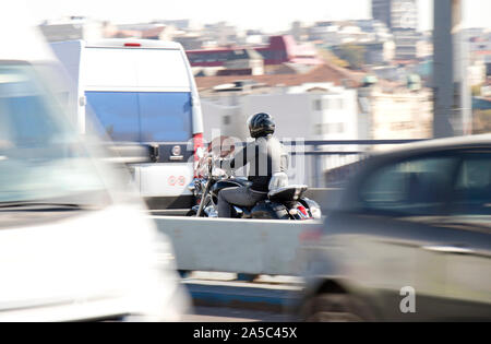 Belgrade, Serbie - 16 octobre 2019 : Un homme à cheval sur la ville de moto Street Bridge dans le trafic important dans le motion blur Banque D'Images