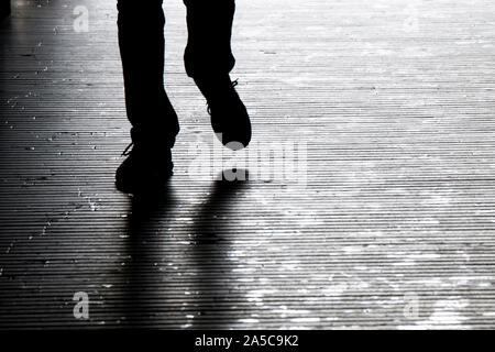 Ombres floues silhouette d'un homme marchant dans la nuit, détail des jambes Banque D'Images