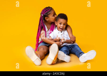 Adorable african american siblings sitting on floor et de câlins Banque D'Images