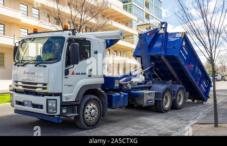 Un chargement d'un camion ouvert à roll-off skip to bin sur l'arrière du camion. Banque D'Images