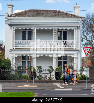 Deux femmes de race blanche avec des enfants en passant devant une maison à East Melbourne Victoria en Australie. Banque D'Images
