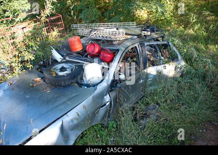 Voiture rouillée abandonnée remplie d'ordures laissées dans la nature Banque D'Images