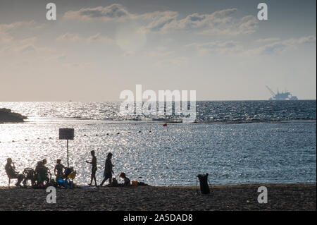 DOR BEACH, Israël / 18 OCT 2019 : détente sur la plage en face de la plate-forme de forage offshore controversé de l'environnement dans l'arrière-plan. Banque D'Images