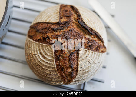 Vue de dessus du délicieux pain bio fait maison placée sur le refroidissement râteau sur comptoir de la cuisine. Banque D'Images