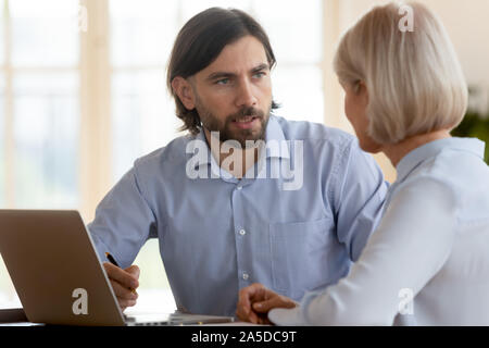 Assureur gestionnaire d'hommes d'âge moyen de consultation expliquant les avantages client Banque D'Images