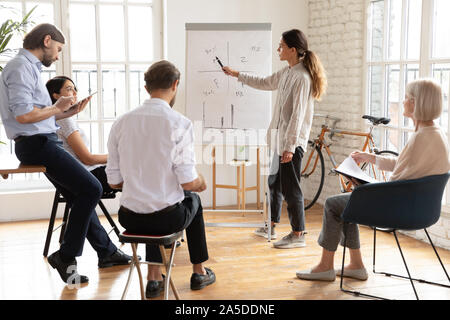 Jeune femme sérieuse manager coach donner présentation à l'atelier de l'entreprise Banque D'Images