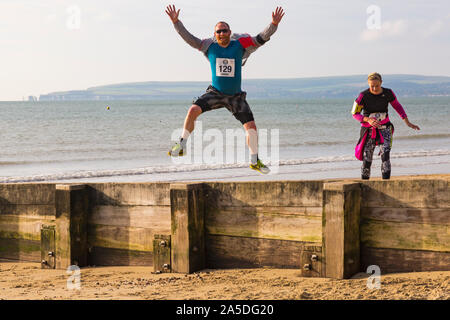 Bournemouth, Dorset, UK. 20 octobre 2019. Les participants prennent part à la plage de la race, de la race la marée, une plage à marée basse le long de la magnifique côte de la plage de Bournemouth vers la plage de Sandbanks. Porteur exécuter le 5k ou 10k race le long du littoral et sur les épis avant la marée monte. Un froid sec tôt le matin avec un peu de soleil. Credit : Carolyn Jenkins/Alamy Live News Banque D'Images