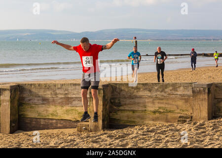 Bournemouth, Dorset, UK. 20 octobre 2019. Les participants prennent part à la plage de la race, de la race la marée, une plage à marée basse le long de la magnifique côte de la plage de Bournemouth vers la plage de Sandbanks. Porteur exécuter le 5k ou 10k race le long du littoral et sur les épis avant la marée monte. Un froid sec tôt le matin avec un peu de soleil. Credit : Carolyn Jenkins/Alamy Live News Banque D'Images