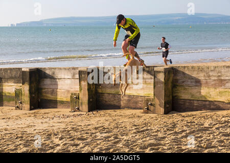 Bournemouth, Dorset, UK. 20 octobre 2019. Les participants prennent part à la plage de la race, de la race la marée, une plage à marée basse le long de la magnifique côte de la plage de Bournemouth vers la plage de Sandbanks. Porteur exécuter le 5k ou 10k race le long du littoral et sur les épis avant la marée monte. Un froid sec tôt le matin avec un peu de soleil. Credit : Carolyn Jenkins/Alamy Live News Banque D'Images