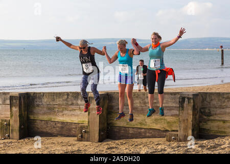 Bournemouth, Dorset, UK. 20 octobre 2019. Les participants prennent part à la plage de la race, de la race la marée, une plage à marée basse le long de la magnifique côte de la plage de Bournemouth vers la plage de Sandbanks. Porteur exécuter le 5k ou 10k race le long du littoral et sur les épis avant la marée monte. Un froid sec tôt le matin avec un peu de soleil. Credit : Carolyn Jenkins/Alamy Live News Banque D'Images