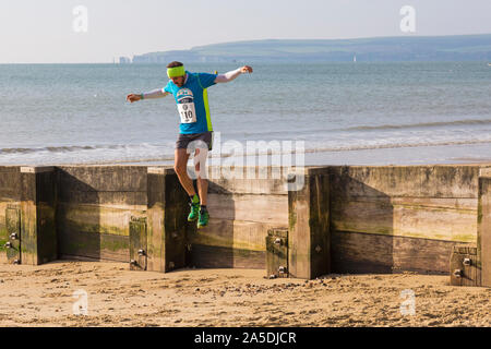 Bournemouth, Dorset, UK. 20 octobre 2019. Les participants prennent part à la plage de la race, de la race la marée, une plage à marée basse le long de la magnifique côte de la plage de Bournemouth vers la plage de Sandbanks. Porteur exécuter le 5k ou 10k race le long du littoral et sur les épis avant la marée monte. Un froid sec tôt le matin avec un peu de soleil. Credit : Carolyn Jenkins/Alamy Live News Banque D'Images