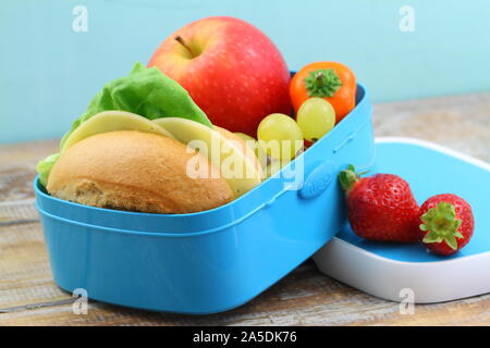 École en santé boîte à lunch contenant du fromage roll, poivron jaune et croquante de fruits : raisin, pomme et fraises Banque D'Images