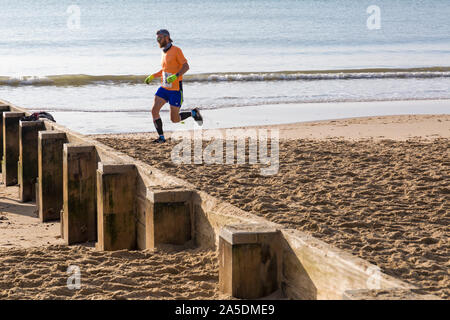 Bournemouth, Dorset, UK. 20 octobre 2019. Les participants prennent part à la plage de la race, de la race la marée, une plage à marée basse le long de la magnifique côte de la plage de Bournemouth vers la plage de Sandbanks. Porteur exécuter le 5k ou 10k race le long du littoral et sur les épis avant la marée monte. Un froid sec tôt le matin avec un peu de soleil. Credit : Carolyn Jenkins/Alamy Live News Banque D'Images