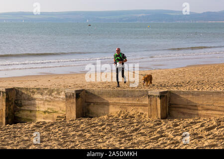 Bournemouth, Dorset, UK. 20 octobre 2019. Les participants prennent part à la plage de la race, de la race la marée, une plage à marée basse le long de la magnifique côte de la plage de Bournemouth vers la plage de Sandbanks. Porteur exécuter le 5k ou 10k race le long du littoral et sur les épis avant la marée monte. Un froid sec tôt le matin avec un peu de soleil. Credit : Carolyn Jenkins/Alamy Live News Banque D'Images