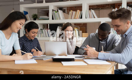 Les étudiants multi-raciale étudier ensemble assis au bureau de la bibliothèque Banque D'Images