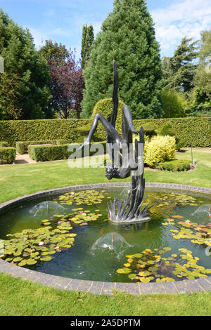 Étang ornemental ronde & Statue de Icarus au jardin de Heroes & Villains Dorsington Stratford-upon-Avon en Angleterre Banque D'Images
