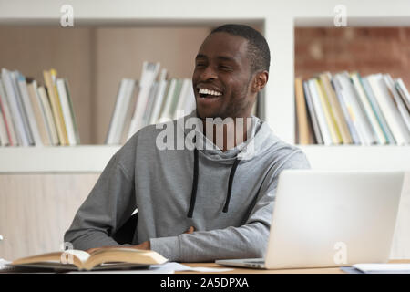 Étudiant africain à accomplir du travail à discuter avec ses amis Banque D'Images