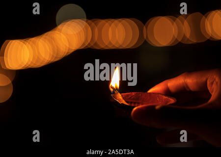 Le Diwali ou deepawali photo avec femme ou une femme tenant une lampe à huile ou diya lors festival de lumière avec un espace réservé au texte isolé sur fond noir. Banque D'Images