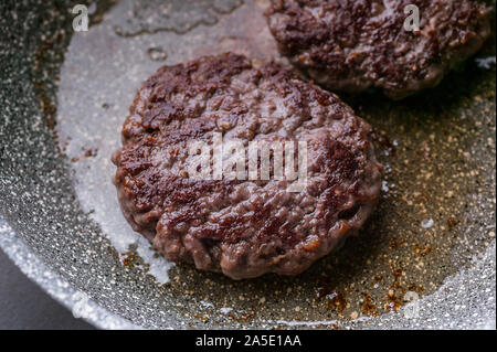 Close-up deux appétissant burger juteux sur une plaque de cuisson. Banque D'Images