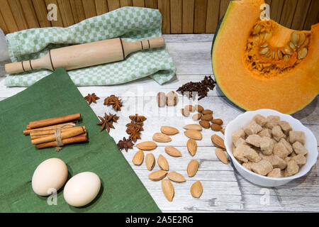 Citrouille fraîche (squash) sur une table de cuisine avec des ingrédients pour la cuisine. Beaucoup d'épices, les noix et les oeufs, sucre brun de canne. Banque D'Images