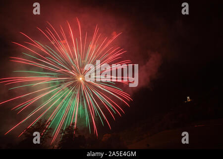 Awesome fontaines d'artifice vert et rouge au-dessus des arbres et une église illuminée Banque D'Images