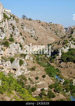 En regardant vers le canyon creusé par la rivière Gravina di Matera, qui coule à l'est de la ville de Matera, Basilicate, Italie. Banque D'Images