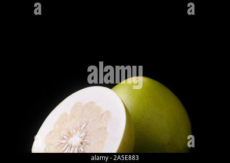 Un demi-tranches de pomelo pomelo et fruits sur fond noir Banque D'Images