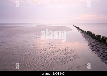 Une ligne de poteaux qui mène à la mer du Nord en Norderney, Allemagne. L'exposition à long shot. Banque D'Images