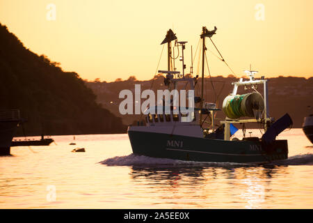 Un bateau de pêche dans l'avant-port de Brixham port que le soleil commence à définir. Brixham est le foyer d'une grande flotte de pêche et marché aux poissons. En Devon Banque D'Images