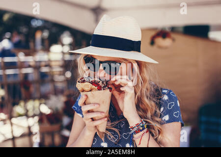 Young blonde woman eating Strawberry Festival à gaufre bulle Banque D'Images