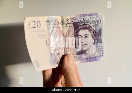 Close up of a senior women holding a utilisé la note de 20 livres. Banque D'Images